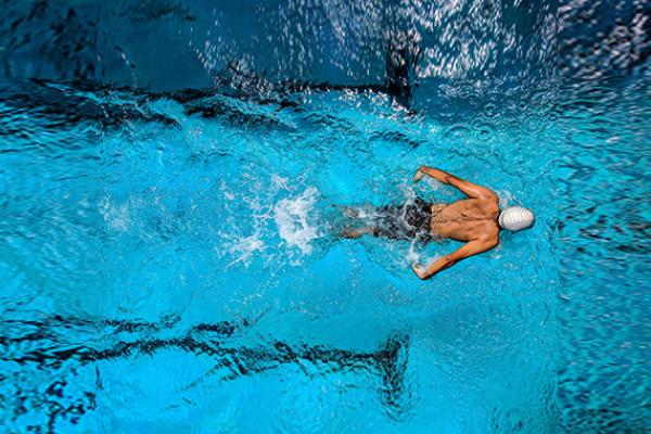 Image for sport infodays news. It depicts a man swimming in a swimming pool.