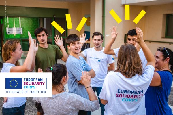 7 youngsters who are part of the eruopean solidarity corps are in a circle with their hands up while one of them is in the middle. The ESC logo is on the bottom left corner and the yellow visual elements are on the top of the image